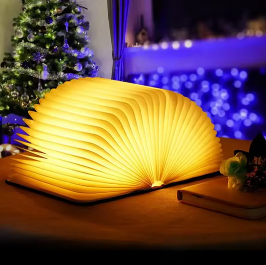 Warm white folding book lamp open on wooden table creating cozy ambient lighting