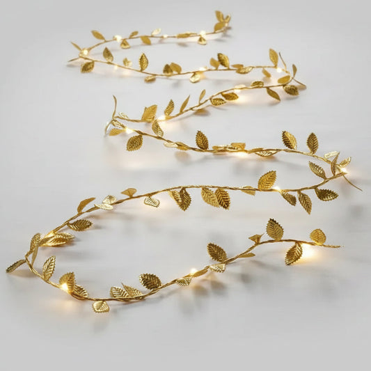 Golden leaf LED string lights with warm white glow on white background